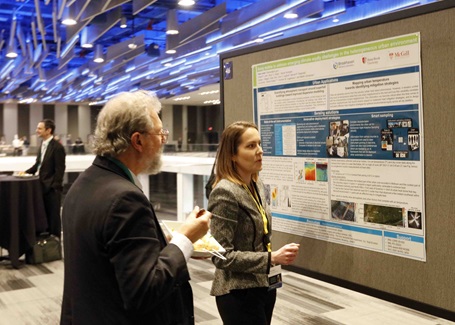 Photo: two conference attendees examining a poster presentation at the battelle conference on innovations in climate resilience